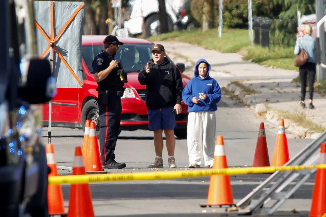 A police officer speaks with members of the public at the scene of a shooting where a police officer was shot outside a Yom Kippur gathering at Sons of Jacob Synagogue in Belleville, Ontario, Canada, on Sept 21, 2026.