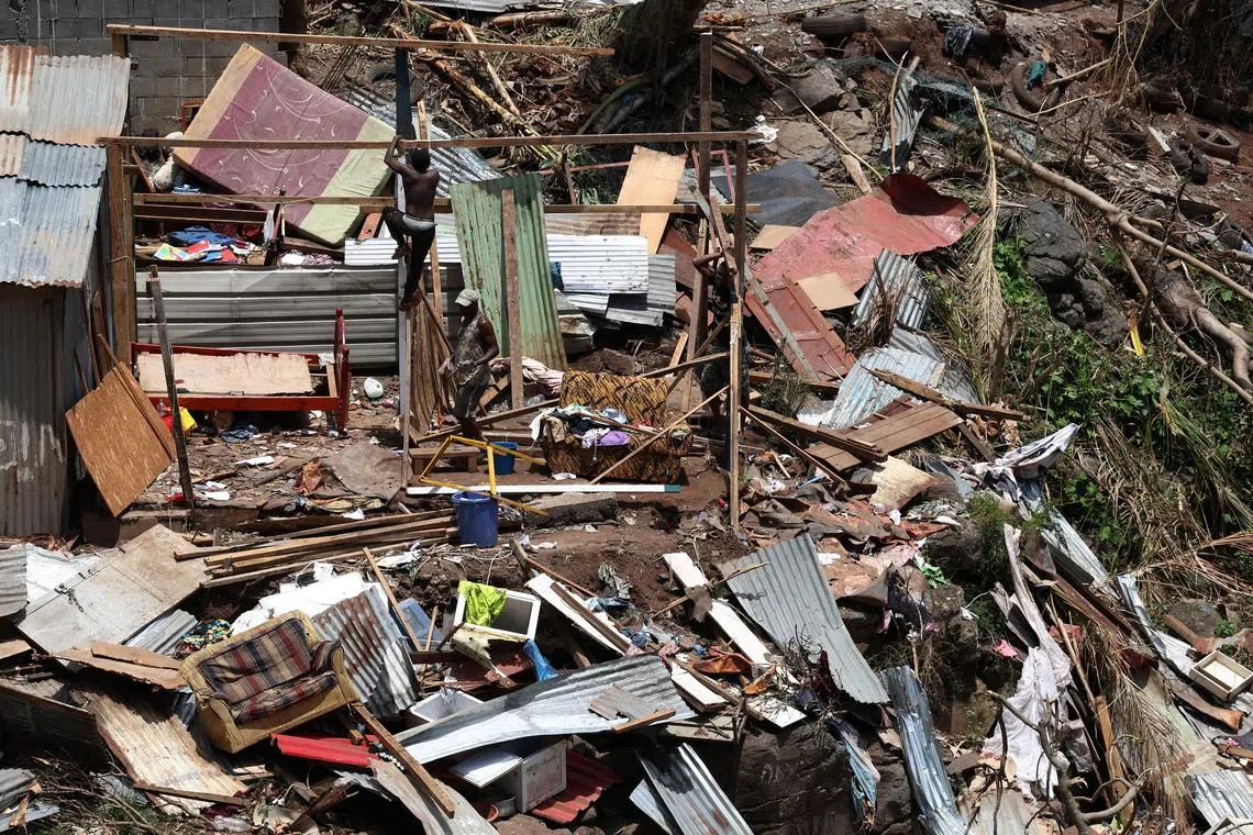 A man inspects a destroyed house in the aftermath of Cyclone Chido, in Kaweni, Mayotte, France, December 18, 2024. REUTERS/Yves Herman