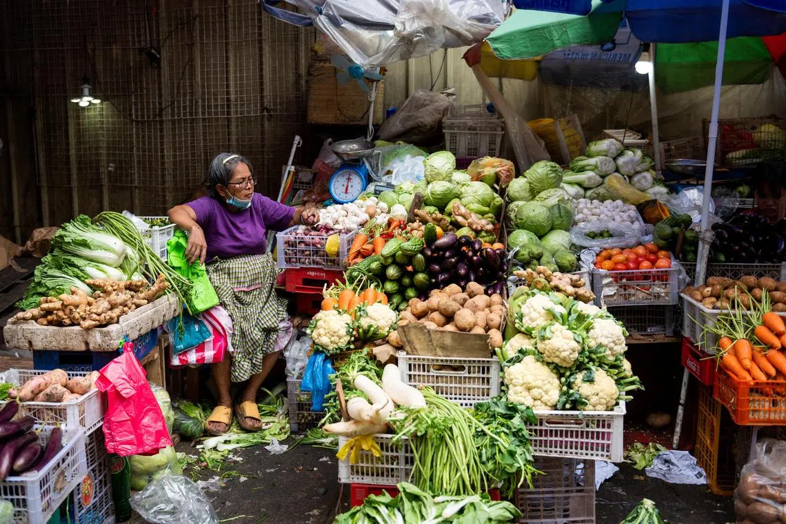 A vegetable vendor tends to her store at a public market in Manila, on Dec 30, 2022.