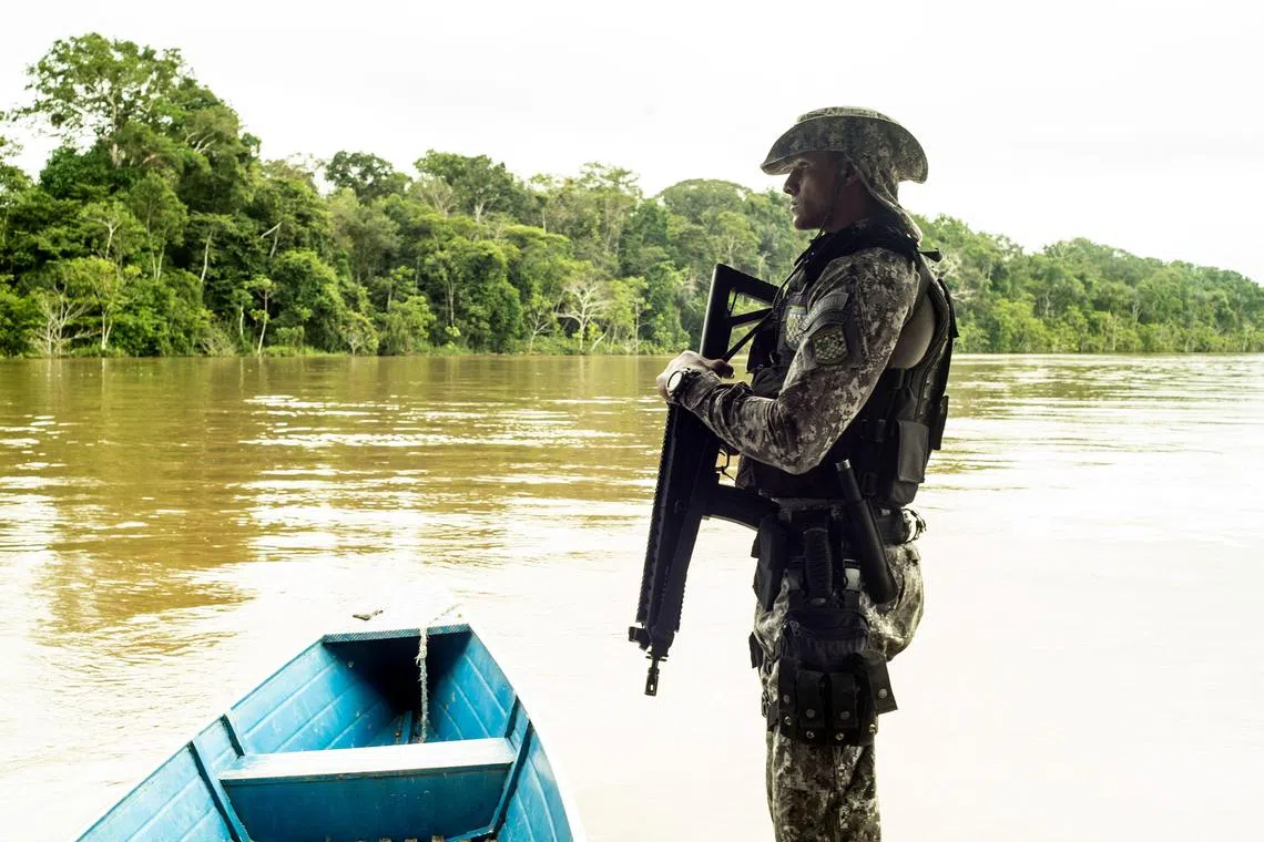 A member of the Brazilian security forces stands guard in the Javary River Valley, in the northwest Amazonas state of Brazil, on May 18, 2023. In the indigenous territory of the Javari Valley, illegal fishermen, poachers, loggers, and narcos continue to plunder and traffic in all manner of ways in these Amazonian outposts in north-west Brazil. (Photo by Hervé BAR / AFP)