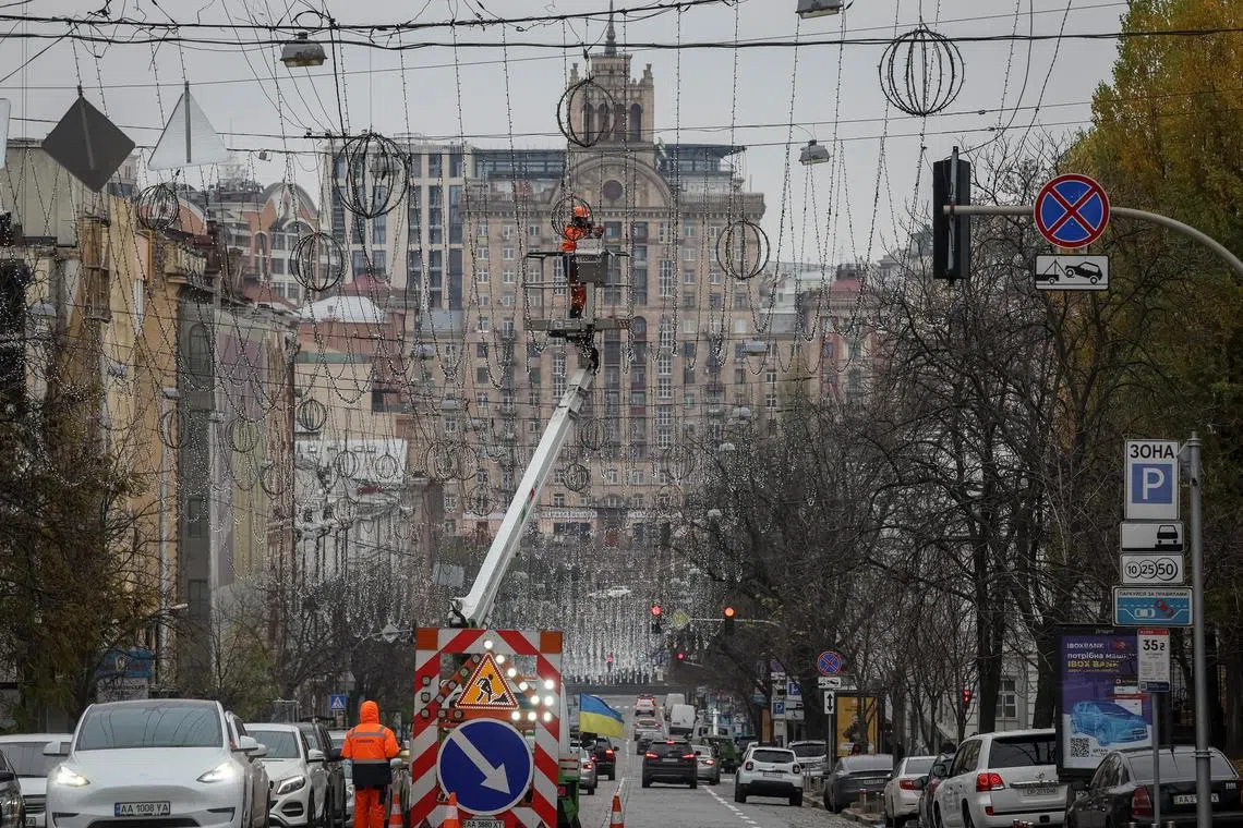 A worker installs decorative lights for the upcoming Christmas and New Year celebrations in central Kyiv, Ukraine on Nov 15, 2022.  