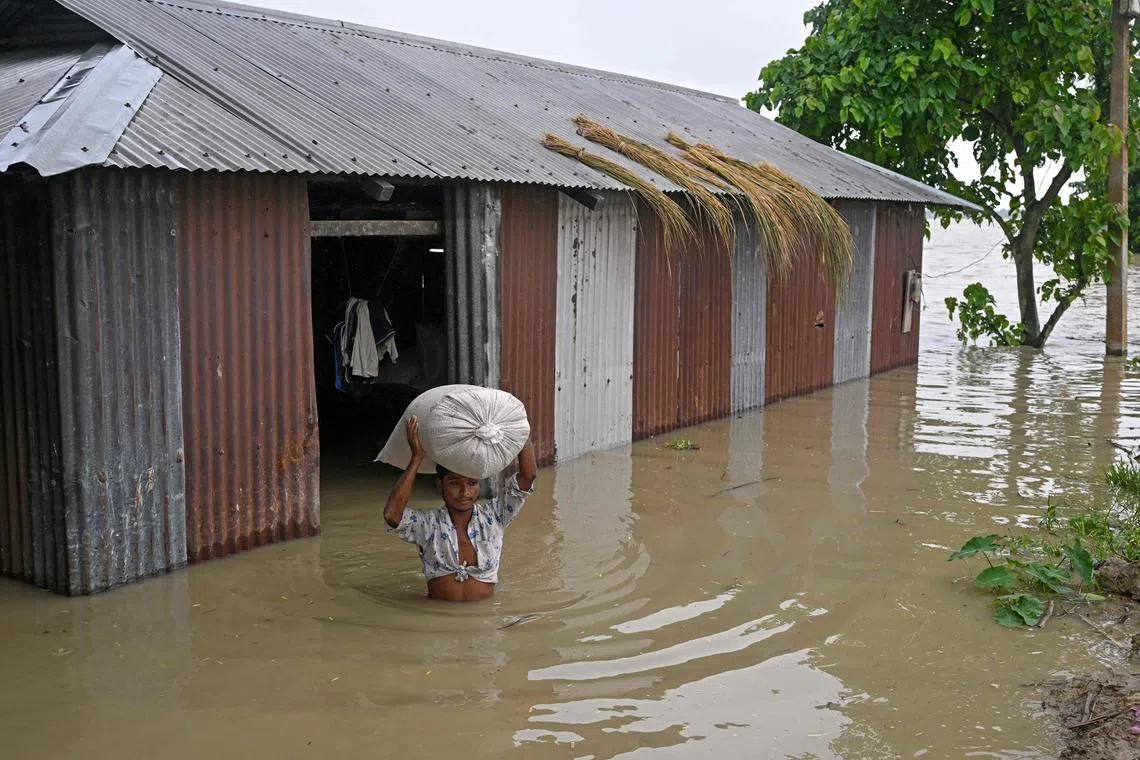 People moved precious belongings and furniture from their water-filled homes in Assam.