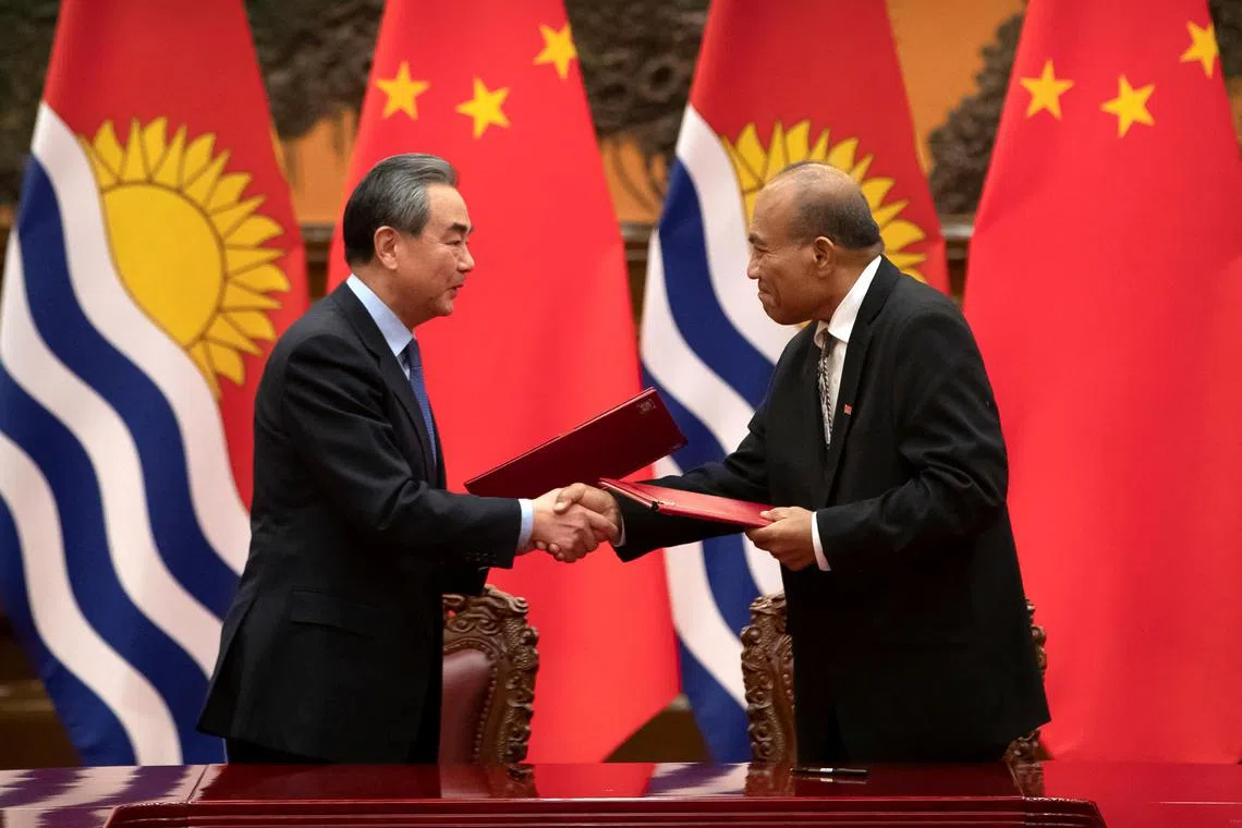 Chinese Foreign Minister Wang Yi and Kiribati's President Taneti Maamau shake hands during a signing ceremony in Beijing, China January 6, 2020.