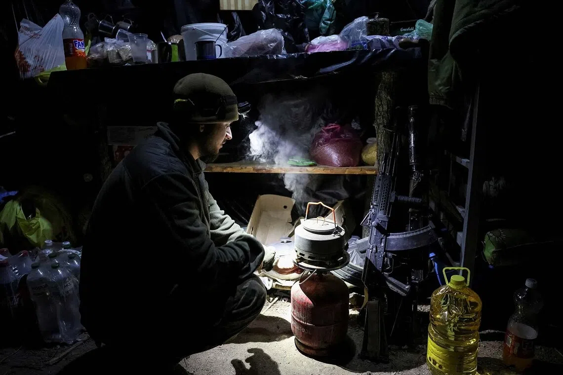 A Ukrainian serviceman preparing tea in a dugout at a position on the front line, amid Russia's attack on Ukraine, near the frontline town of Pokrovsk in Donetsk region, Ukraine, Nov 23, 2025. 