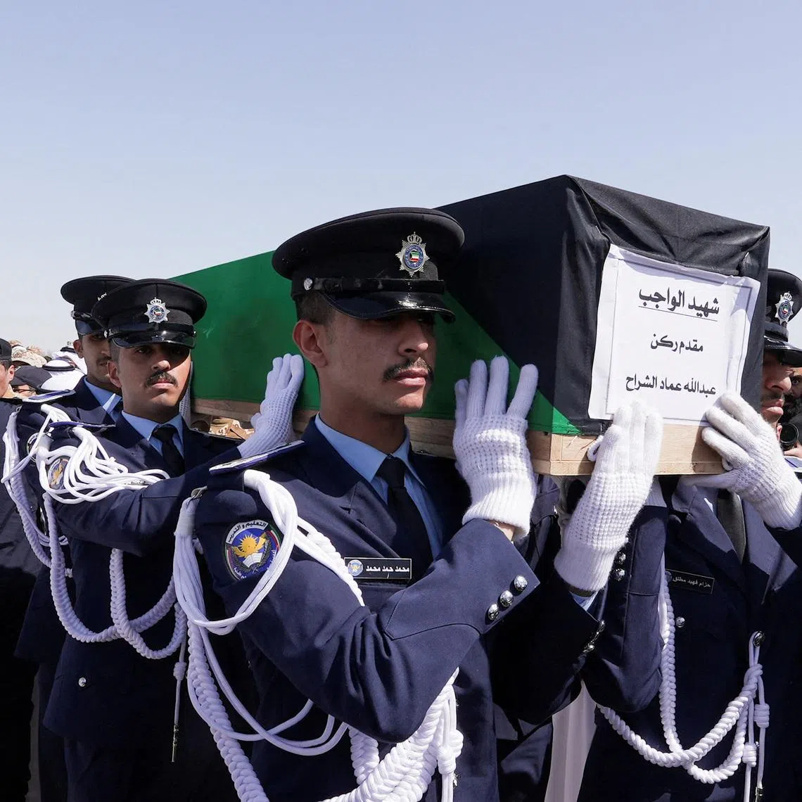 Guards of Honour carry the coffin of one of two police officers, who were killed while performing their duties, during their funeral procession at a graveyard in Kuwait City, Kuwait, March 9, 2026. REUTERS/Mohammed Benmansour