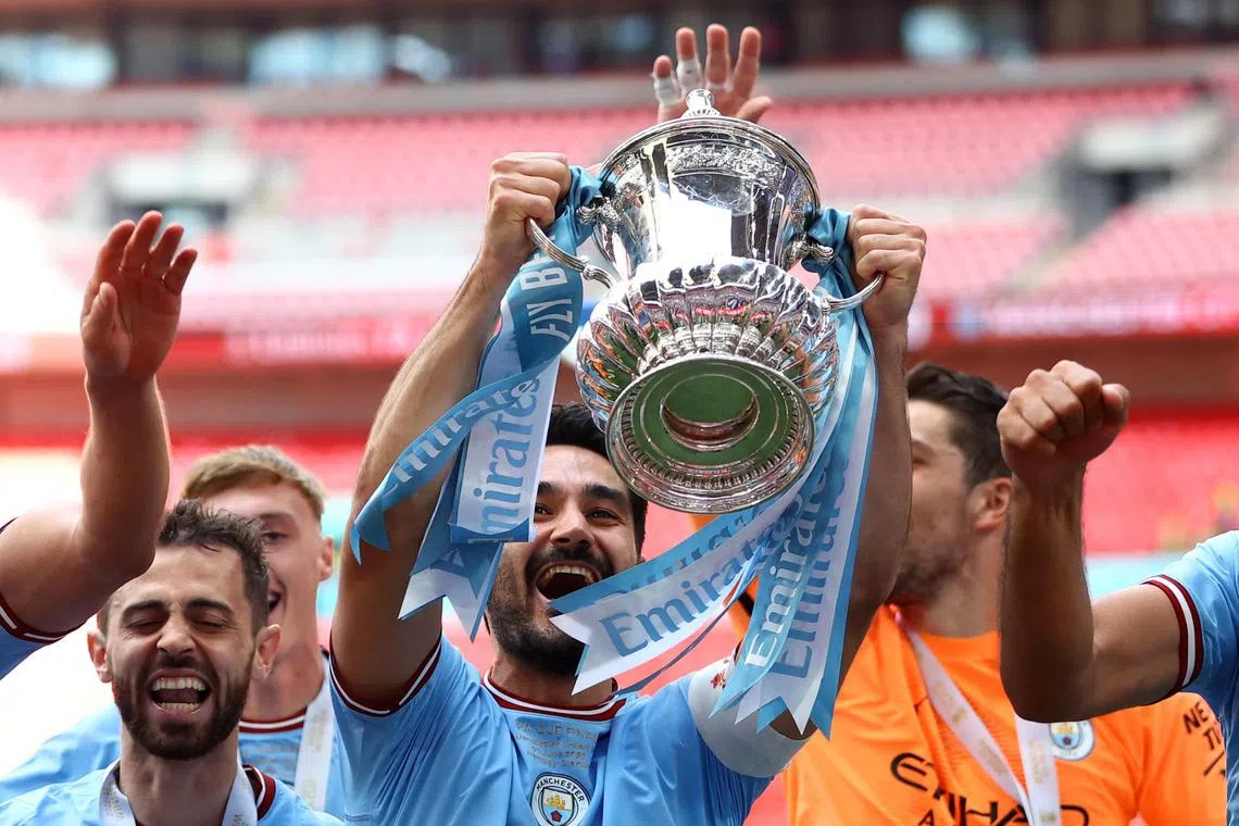 Manchester City's Ilkay Gundogan celebrates with the trophy and his teammates after winning the FA Cup.