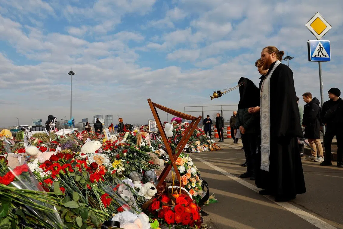 Clergymen conduct a memorial service for victims at a makeshift memorial near the Crocus City Hall following a deadly attack on the concert venue outside Moscow, Russia, March 29, 2024. REUTERS/Evgenia Novozhenina