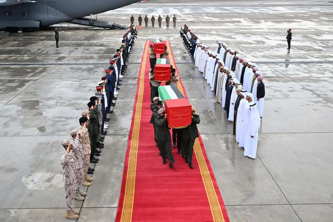 UAE military personnel carry 3 coffins of military personnel killed in Somalia, as they march on red carpet laid out at an airport in Abu Dhabi, UAE, February 11, 2024. WAM/Handout via REUTERS