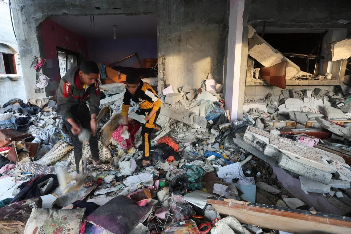 Palestinian boys inspect inside a house damaged in an Israeli strike.