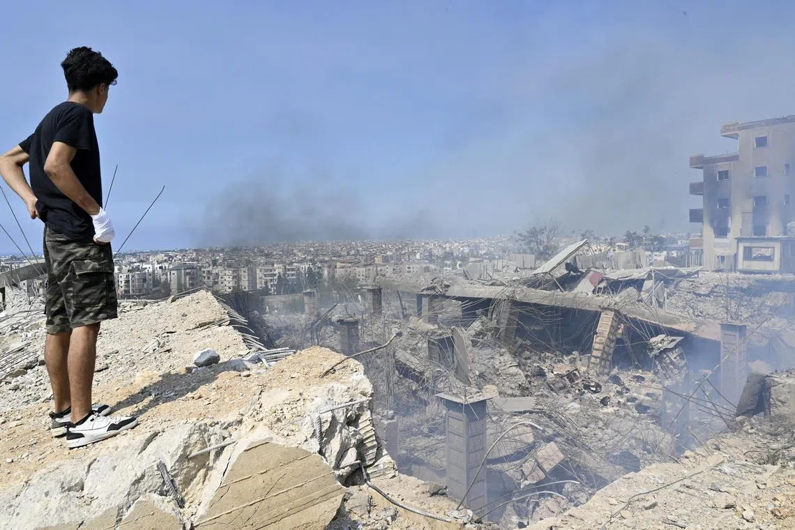 A man looks at a damaged building at the site of an Israeli airstrike in Choueifat, southeast of Beirut, Lebanon, on Sept 28, 2024.