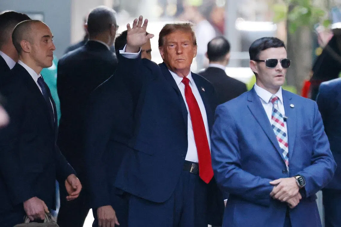 Former US president Donald Trump (centre) exits Trump Tower on his way to New York's Criminal Court for the first day of his hush money trial.