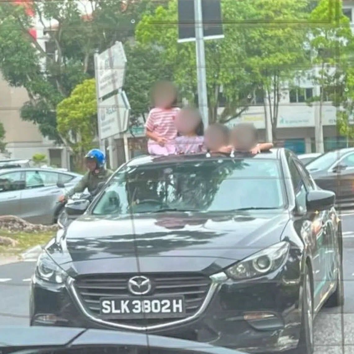 The children can be seen sticking out of a GetGo car’s sunroof, with the child on the far left appearing perched on the roof of the car.