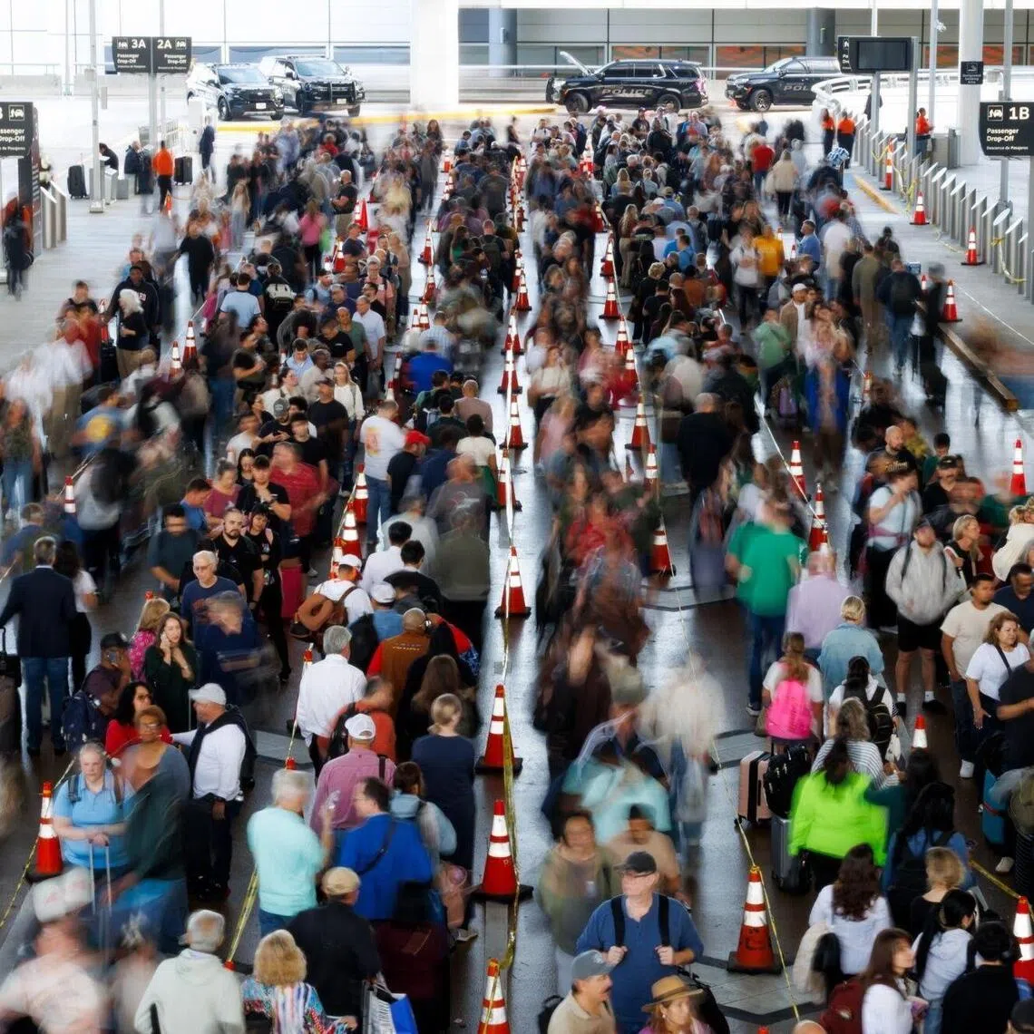 Travellers wait in line at a Transportation Security Administration (TSA) checkpoint at George Bush Intercontinental Airport in Houston, Texas.