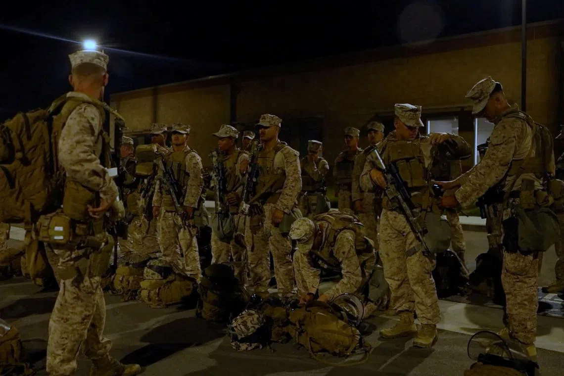 U.S. Marines stand with their packs and weapons, as protests against federal immigration sweeps continue, in greater Los Angeles, California, U.S., June 9, 2025, in this screen grab taken from a handout video. DVIDS/Handout via REUTERS/File Photo