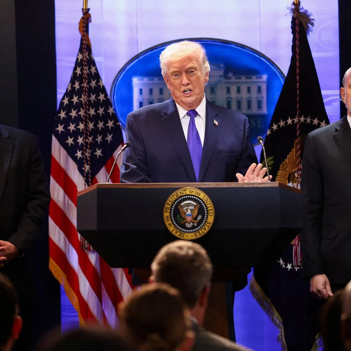 U.S. President Donald Trump, flanked by Secretary of Commerce Howard Lutnick and Solicitor General D. John Sauer, speaks during a press briefing at the White House, following the Supreme Court's ruling that Trump had exceeded his authority when he imposed tariffs, in Washington, D.C., U.S., February 20, 2026. REUTERS/Kevin Lamarque