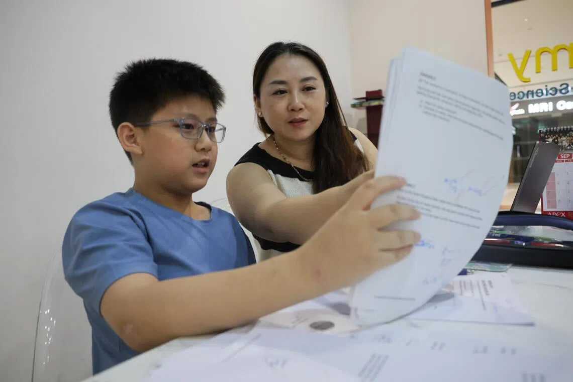 Primary 6 pupil Lucas Yee being reminded by his mother, Jessy Liu, to slow down and check his work.