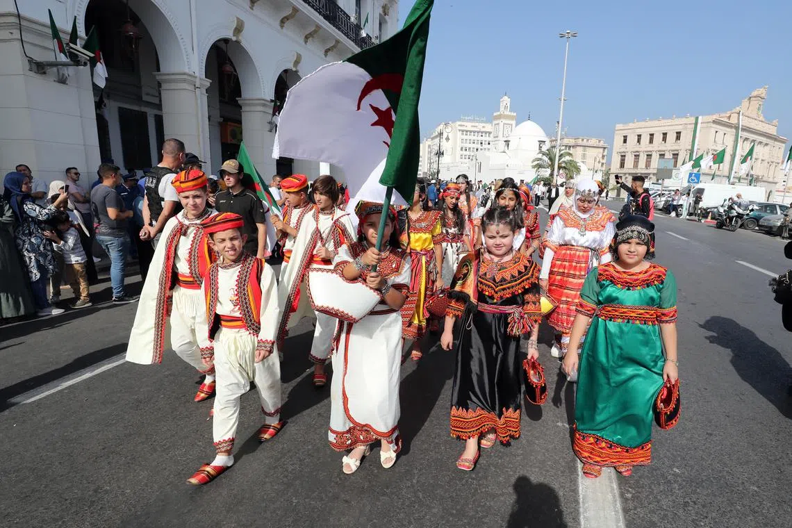 Algerian children wearing traditional clothes during a parade held on the eve of the 31st Arab Summit on Oct 31, 2022.