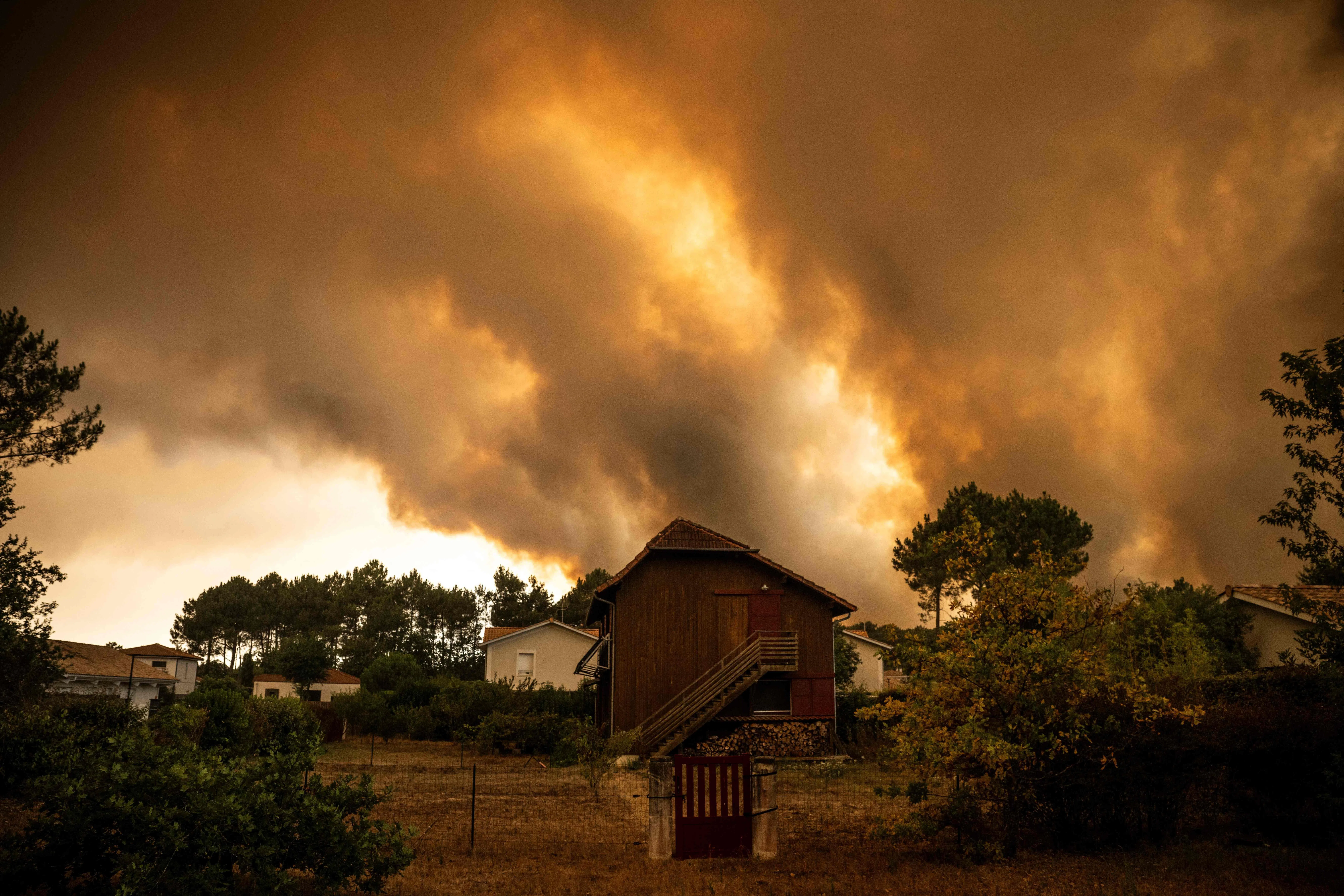 Smoke rising behind houses in a residential area during a wildfire near Lege-Cap-Ferret, southwestern France, on July 23.