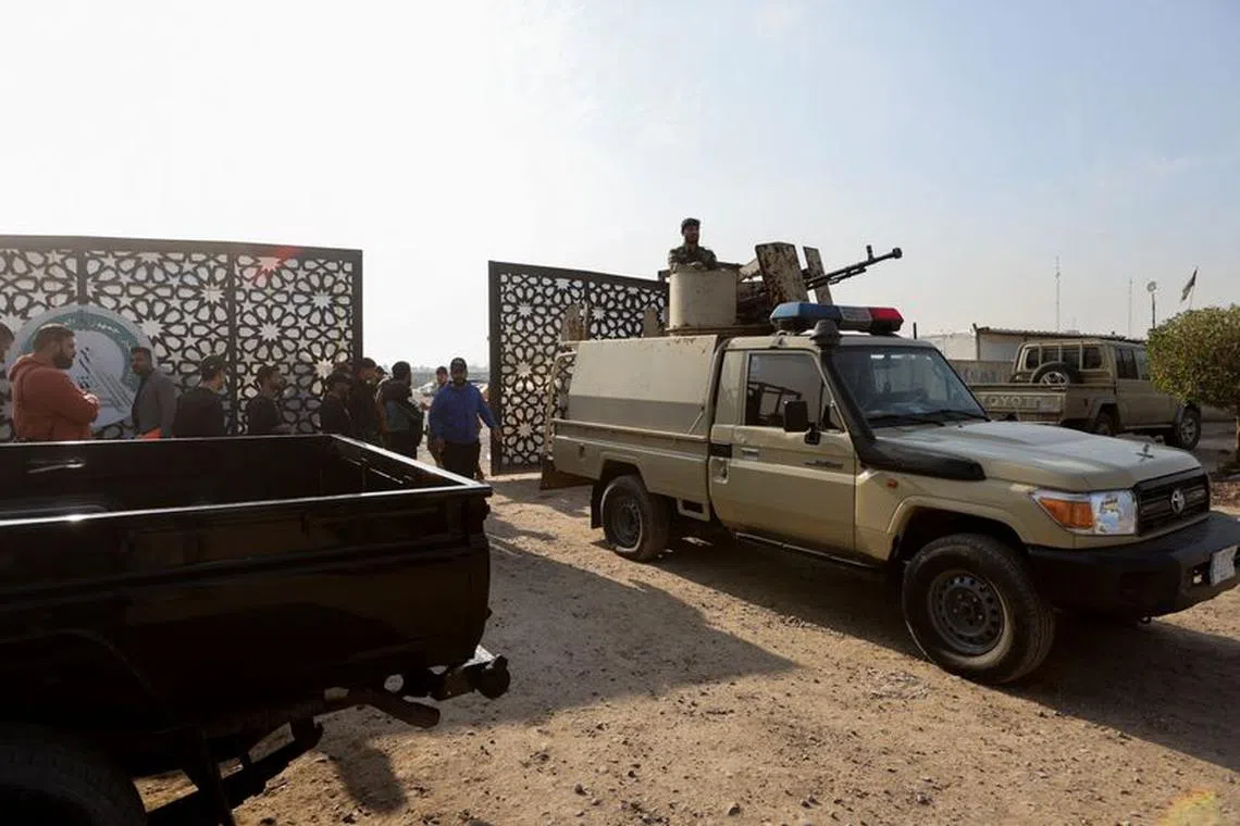 FILE PHOTO: Members of an Iraqi Shi'ite armed group sit in a vehicle after an attack by a drone strike on an Iran-backed militia headquarters in Baghdad, Iraq January 4, 2024. REUTERS/Ahmed Saad/File Photo