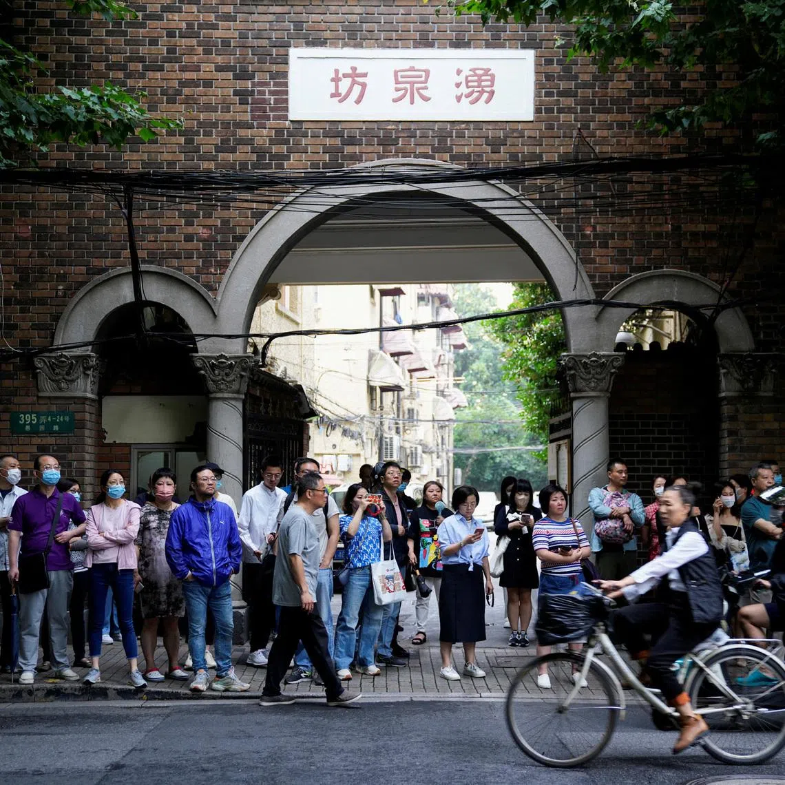 Parents wait for students behind a police line during the annual national college entrance exam at a high school in Shanghai, China on June 7, 2023.