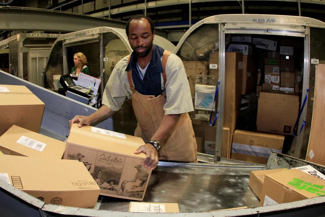 A UPS employee loads packages into air cargo containers at one of the company's facilities in Louisville, Kentucky.