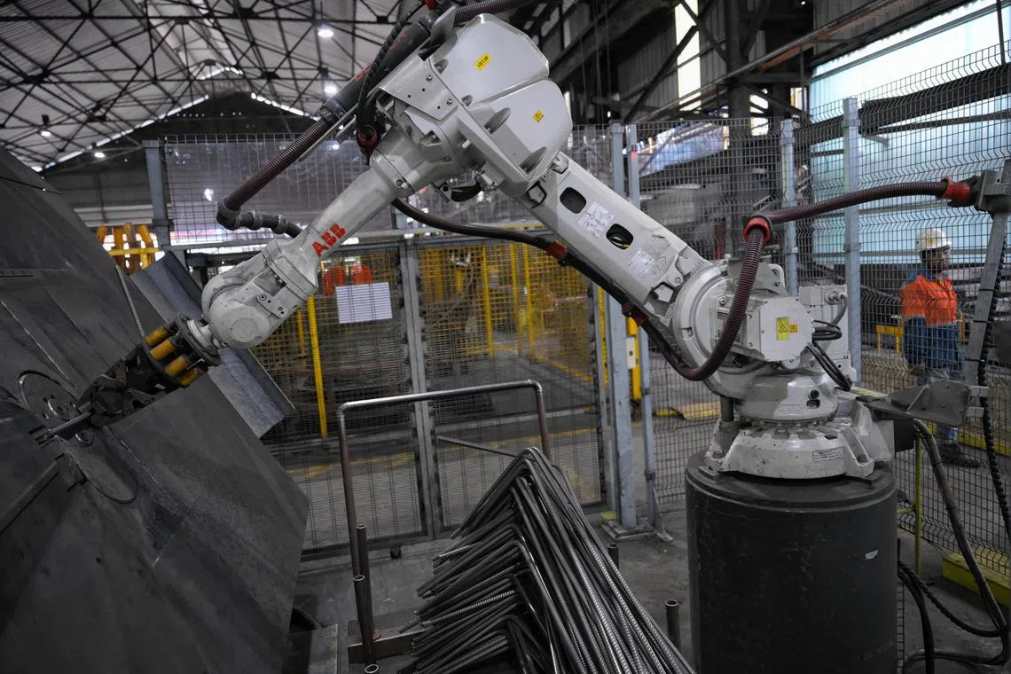 A robotic arm used to remove steel bars at metalworking firm NatSteel.  It reduces workers' hand contact with steel bars, which may lead to abrasions over time.