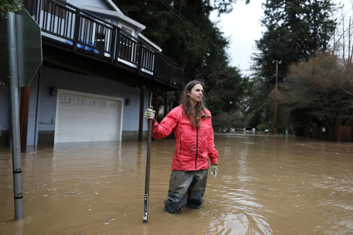 Felton resident Melissa Foley helps to clear debris in her neighbourhood, amid more flooding, on Jan 14, 2023.