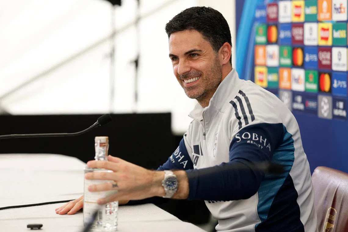 Soccer Football - UEFA Champions League - Final - Arsenal Media Open Day - Arsenal Training Centre, London Colney, Britain - May 21, 2026 A journalist gives a bottle of mezcal to Arsenal manager Mikel Arteta as a present, during the press conference on Arsenal Media Open Day Action Images via Reuters/Peter Cziborra
