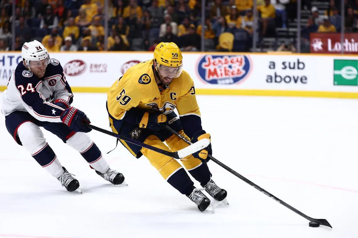 FILE PHOTO: Oct 26, 2024; Nashville, Tennessee, USA; Nashville Predators defenseman Roman Josi (59) moves the puck away from Columbus Blue Jackets right wing Mathieu Olivier (24) in the second period at Bridgestone Arena. Mandatory Credit: Casey Gower-Imagn Images/File Photo