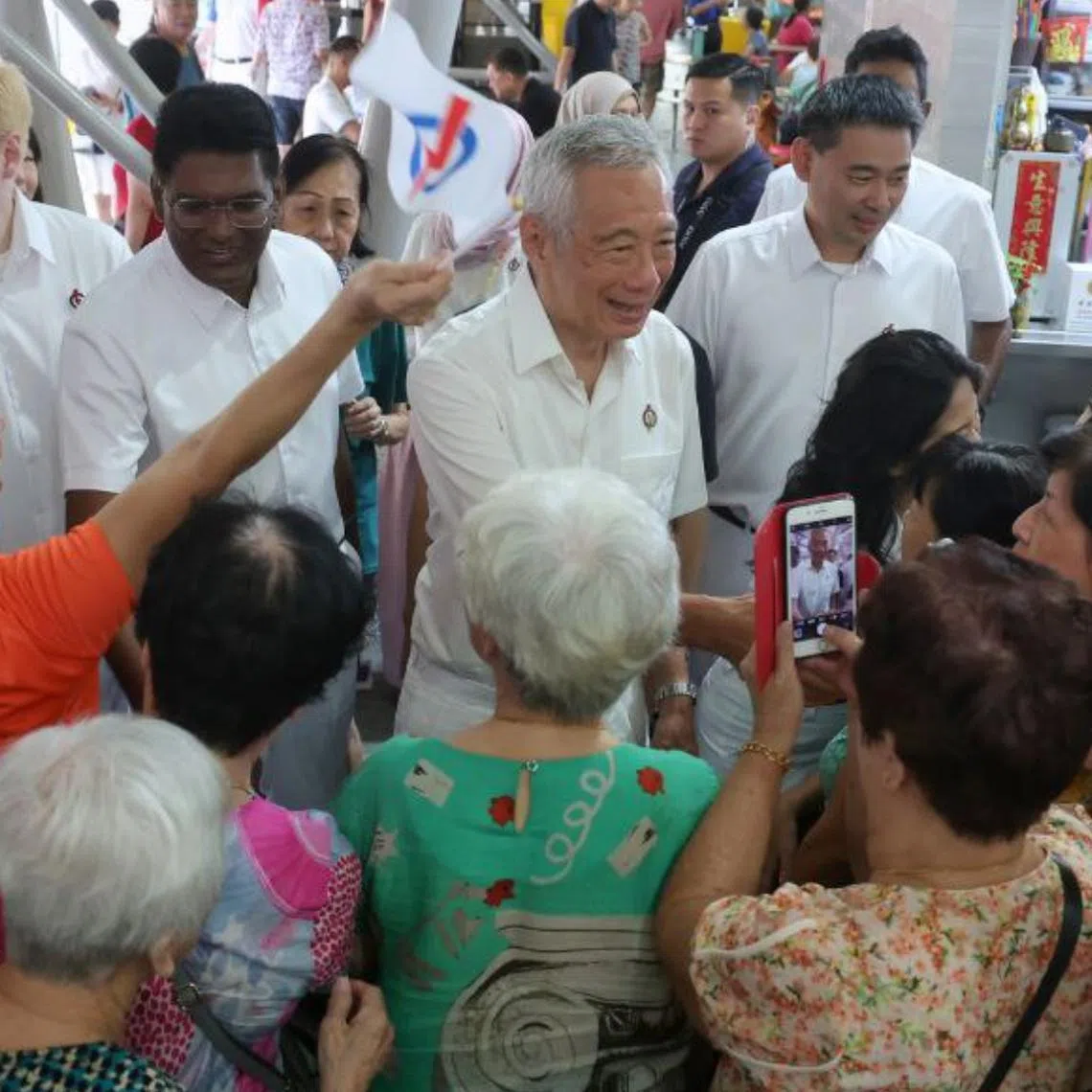 Senior Minister Lee Hsien Loong and the PAP Aljunied GRC team interacting with residents during a walkabout at Bedok Reservoir Road Market and Food Centre on April 29.