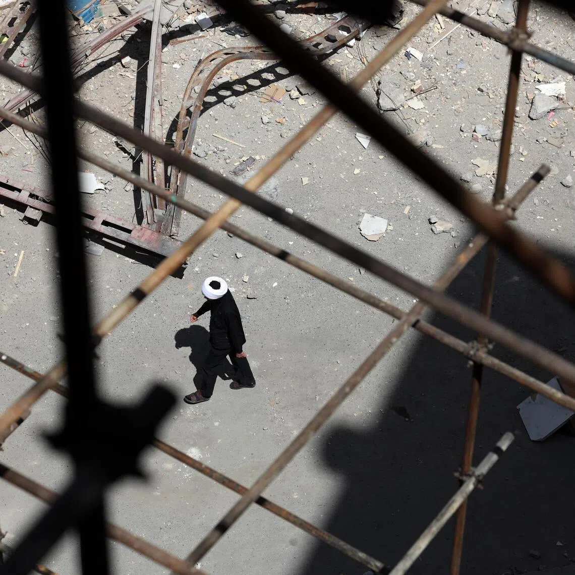An Iranian cleric walks around the scene of residential buildings which were destroyed by US-Israeli airstrikes at the Shahid Broujerdi residential complex in southern Tehran, Iran, on April 14, 2026.