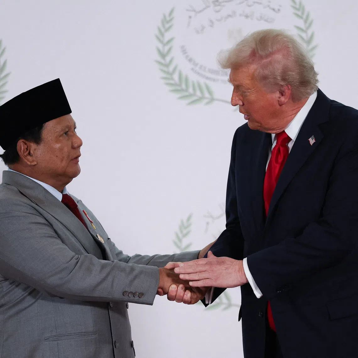 U.S. President Donald Trump and Indonesian President Prabowo Subianto shake hands as they pose for a photo, at a world leaders' summit on ending the Gaza war, amid a U.S.-brokered prisoner-hostage swap and ceasefire deal between Israel and Hamas, in Sharm el-Sheikh, Egypt, October 13, 2025. REUTERS/Suzanne Plunkett/Pool