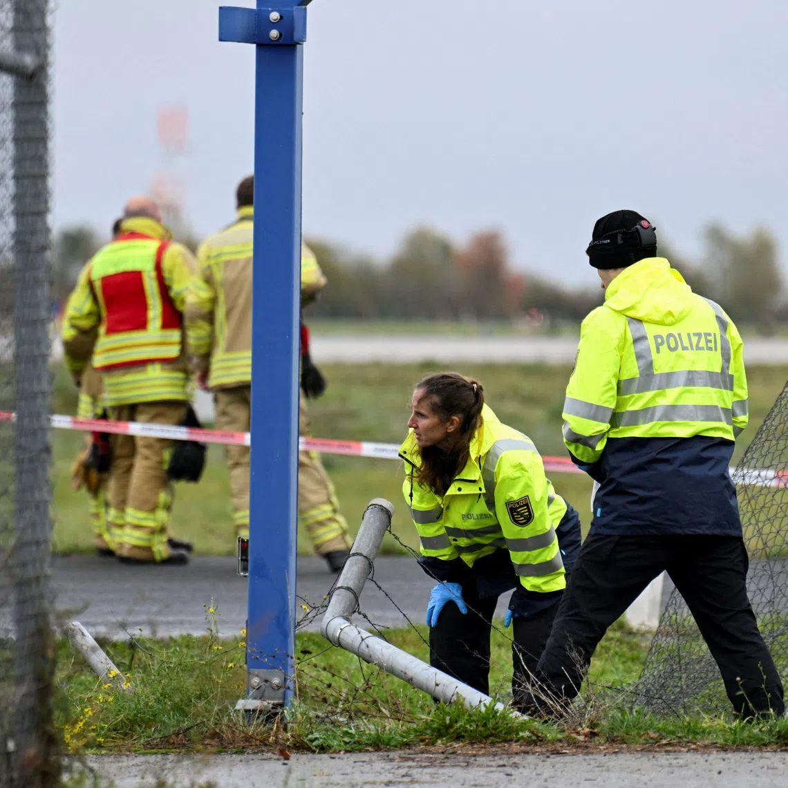 Police officers investigate a fence breach at Leipzig/Halle Airport, where a vehicle appeared to have driven through a fence, in Schkeuditz, Germany, October 18, 2026. REUTERS/Annegret Hilse