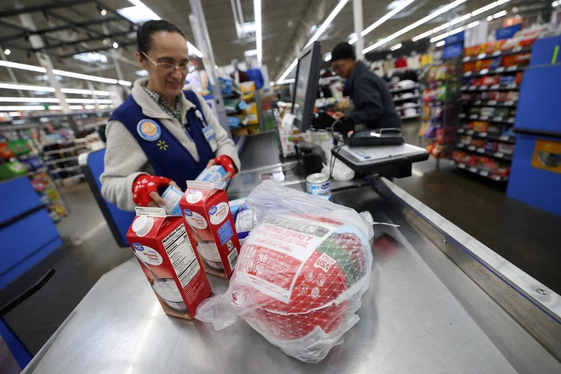 FILE PHOTO: A cashier loads a turkey and other groceries for checkout at a Walmart Supercenter retail store in North Bergen, New Jersey, U.S., November 21, 2025.  REUTERS/Mike Segar/File Photo