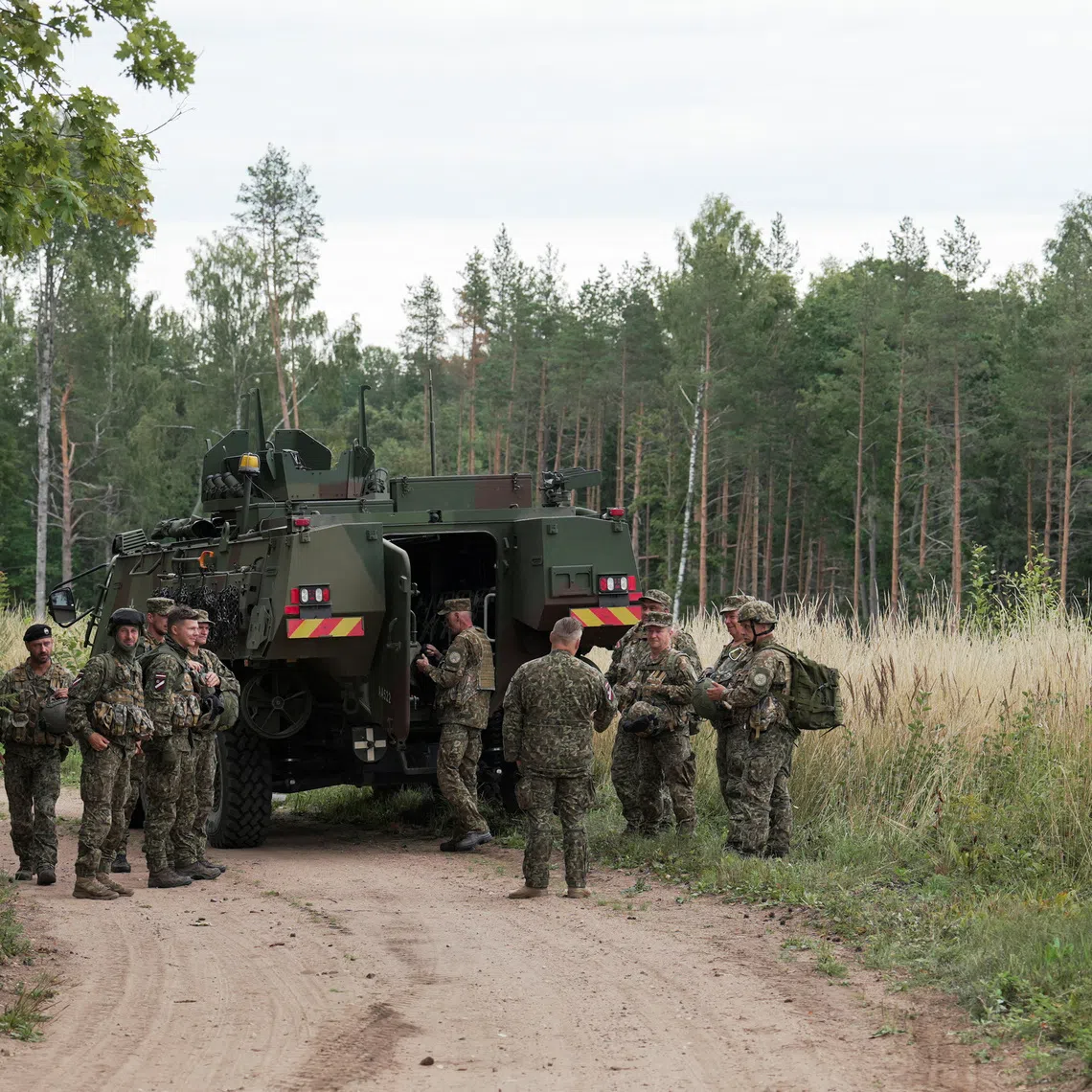 Servicemen of the Latvian National Guard gather before a search operation for the debris from an intercepted drone, amid Russia's attack on Ukraine, in Rugaji, Latvia, August 14, 2026. REUTERS/Janis Laizans