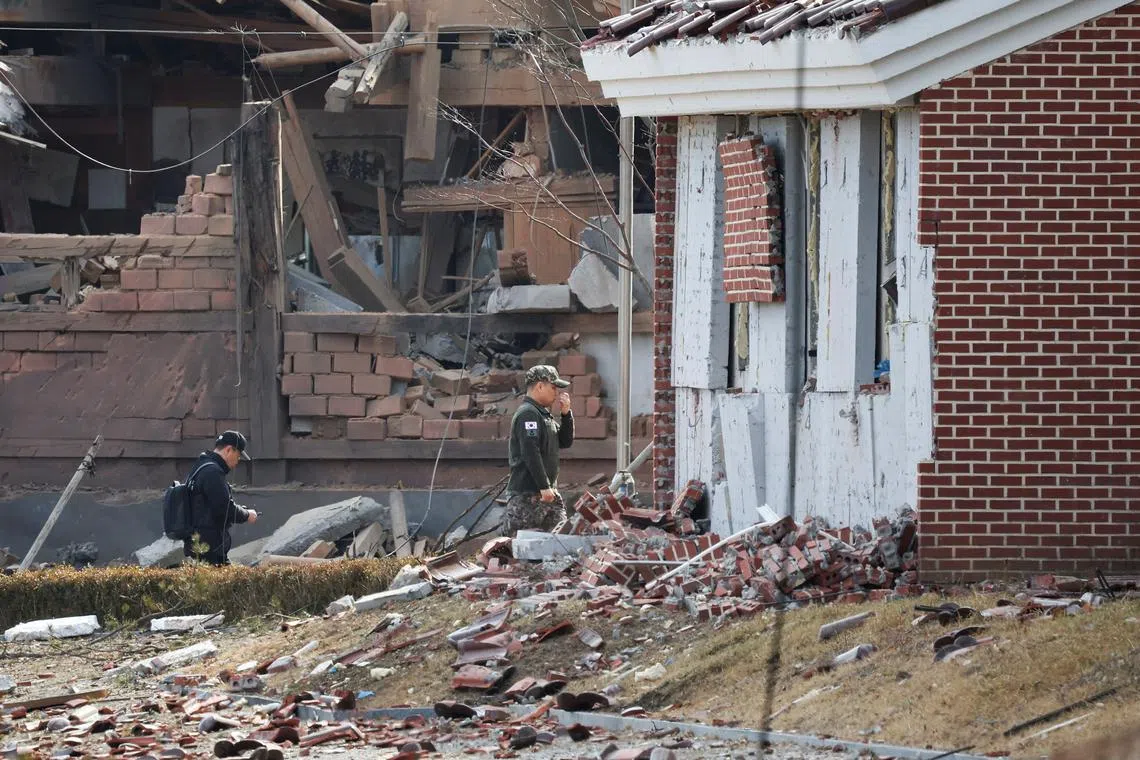 Officials inspect an area with damaged buildings after South Korea's Air Force said that Mk82 bombs fell from a KF-16 jet outside the shooting range during joint live-fire exercises near the demilitarized zone separating two Koreas in Pocheon, South Korea, March 6, 2025. REUTERS/Kim Hong-Ji