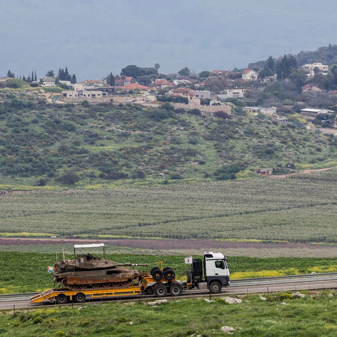 An Israeli tank is transported near the Israeli side of the border with Lebanon, amid escalating hostilities between Israel and Hezbollah, as the U.S.-Israeli conflict with Iran continues, in northern Israel, March 26, 2026. REUTERS/Tyrone Siu