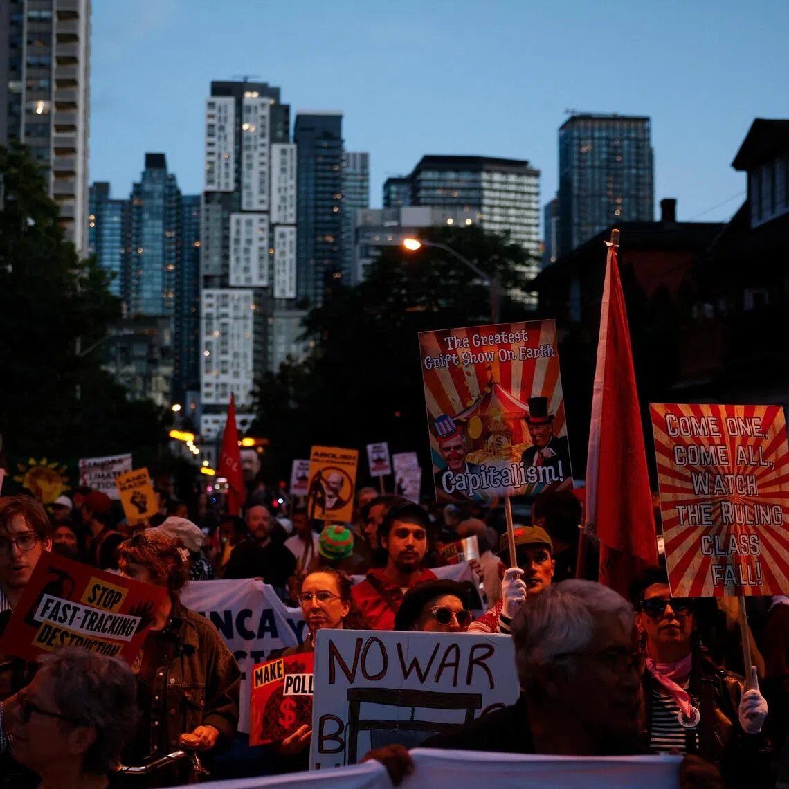 Protesters march on the day of the opening night gala dinner of the Canada Investment Summit, in Toronto, Ontario, Canada, on Sept 14.