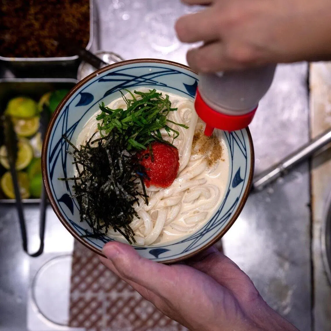 An employee prepares a bowl of udon noodles at a Marugame Seimen restaurant in Tokyo.