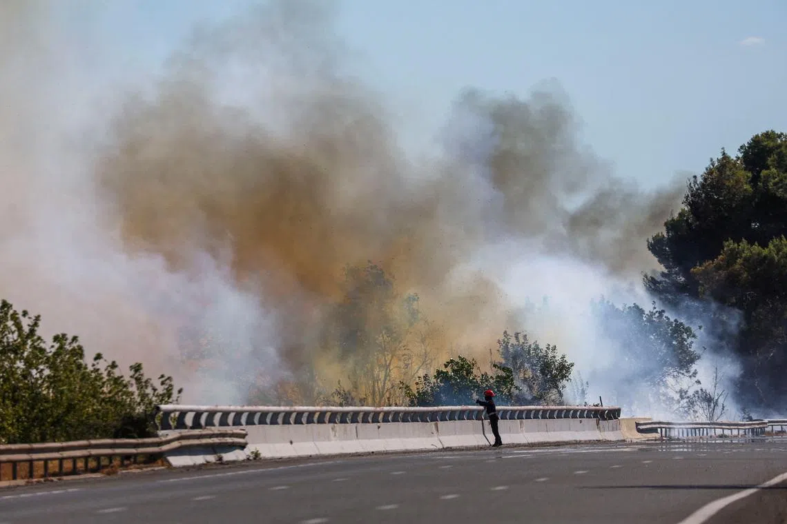A firefighter works to battle wildfire near the A9 motorway near Beziers, France, July 3, 2026. REUTERS/Abdul Saboor
