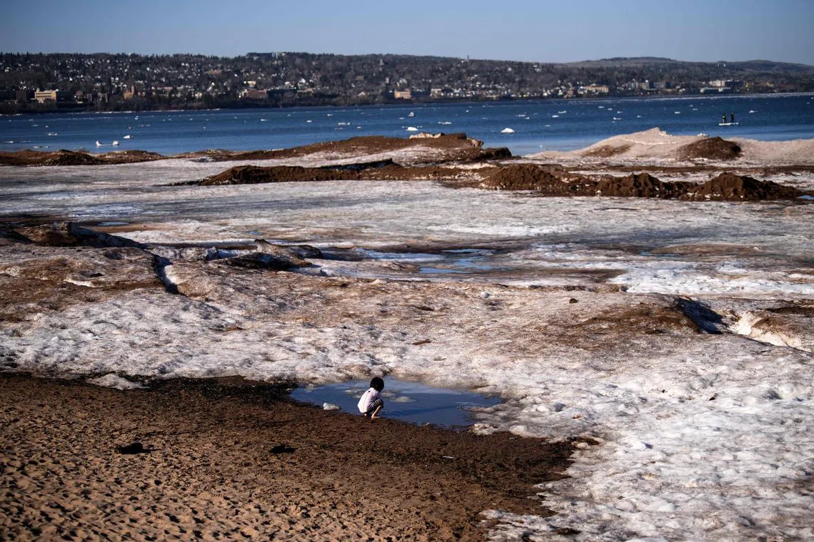 A child playing in a puddle of melting ice and snow along the beach in Duluth, Minnesota, on April 12.