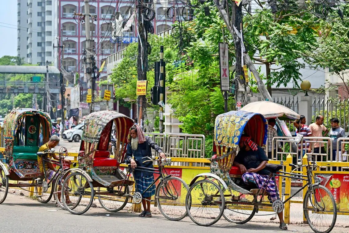 Rickshaw pullers rest amid severe heatwave in Dhaka on April 25, 2024. 