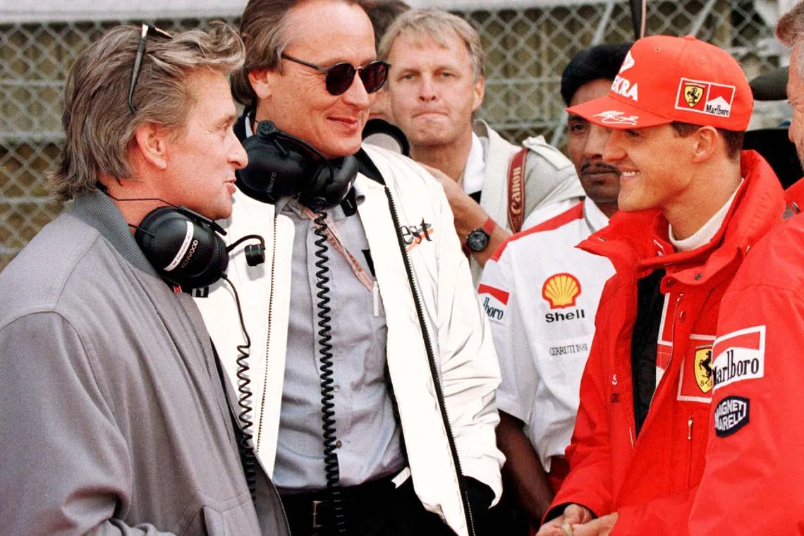 FILE PHOTO: Mansour Ojjeh (C) director of TAG Electronics and actor Michael Douglas (L) talk with Michael Schumacher of Germany prior to the Austrian Grand Prix September 21, 1997/File Photo