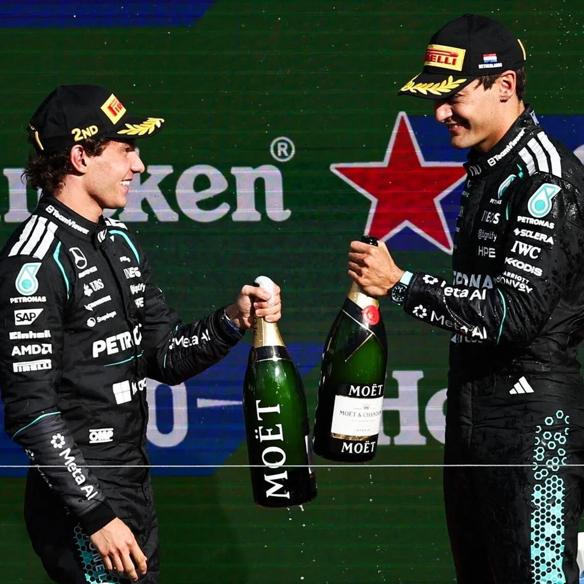 Mercedes drivers Kimi Antonelli (left) and George Russell celebrate on the podium after placing second and third at the Dutch Grand Prix at Zandvoort.