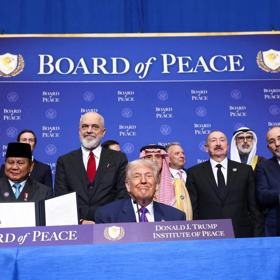 U.S President Donald Trump, Vice President JD Vance, Albania's Prime Minister Edi Rama,  Saudi Minister of State for Foreign Affairs, Cabinet Member, and Climate Envoy Adel Al-Jubeir, Azerbaijani President Ilham Aliyev, and Jordan's Foreign Minister Ayman Safadi present signed documents of the declaration of the funding donors to the Board of Peace, during the inaugural Board of Peace meeting at the U.S. Institute of Peace in Washington, D.C., U.S., February 19, 2026. REUTERS/Kevin Lamarque