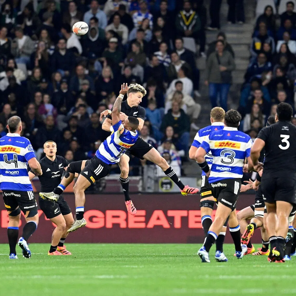 Stormers’ wing Leolin Zas leaps with New Zealand’s fly-half Beauden Barrett during a rugby union tour match at the Cape Town Stadium on Aug 7.