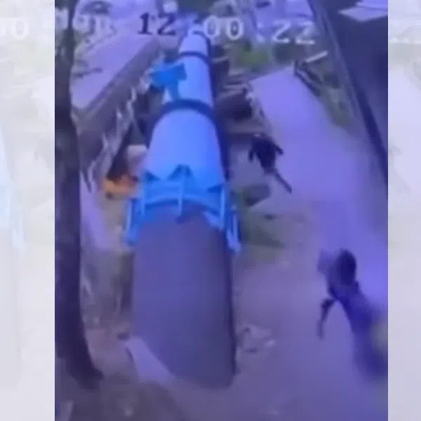 A screenshot from a video taken from a security camera shows three children running away after setting a homeless man on fire in Bangkok.