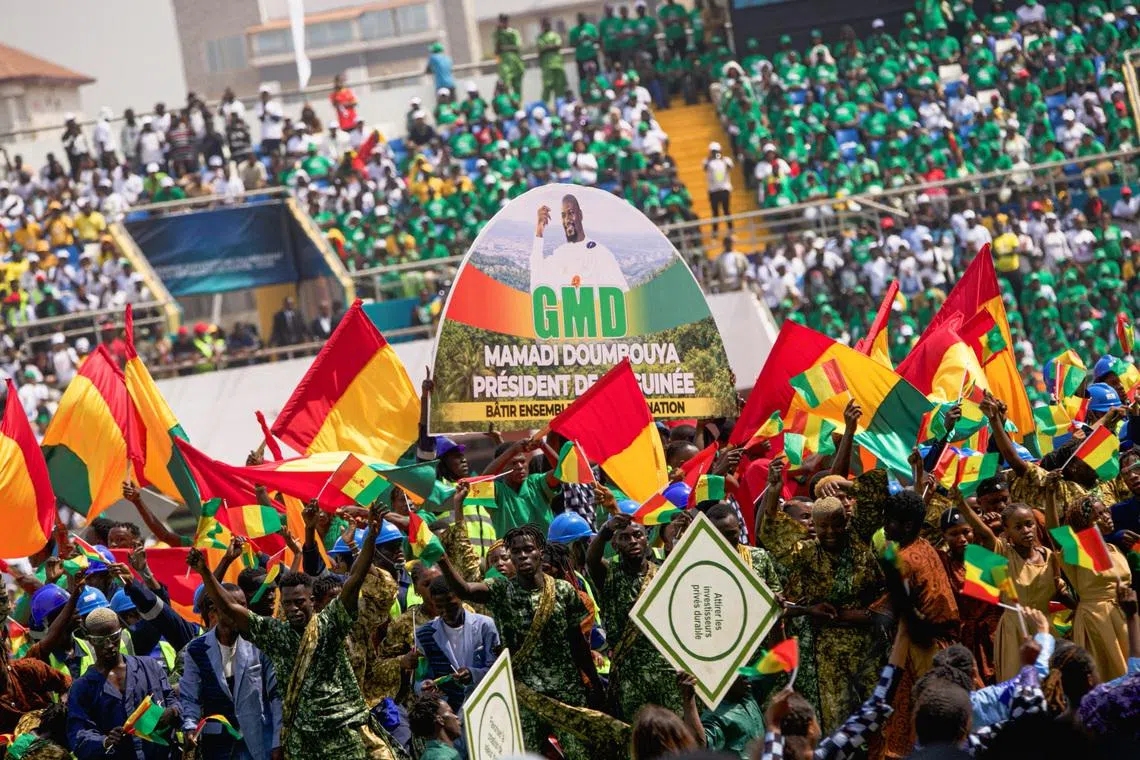 Supporters of Guinea's President-elect Mamady Doumbouya hold Guinean flags during his swearing-in ceremony in Conakry, Guinea, January 17, 2026. REUTERS/Souleymane Camara
