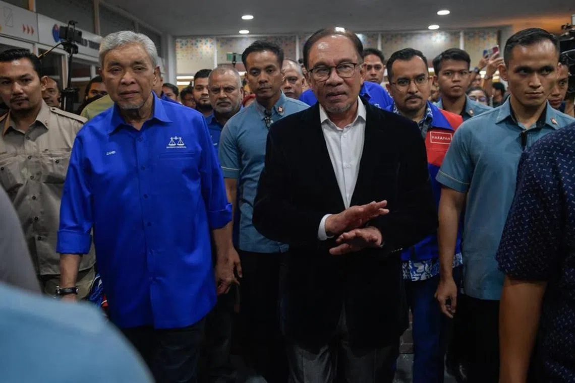 Pakatan Harapan chairman Anwar Ibrahim accompanied by Barisan Nasional chairman Zahid Hamidi in Umno headquarters at the World Trade Centre on Aug 12.