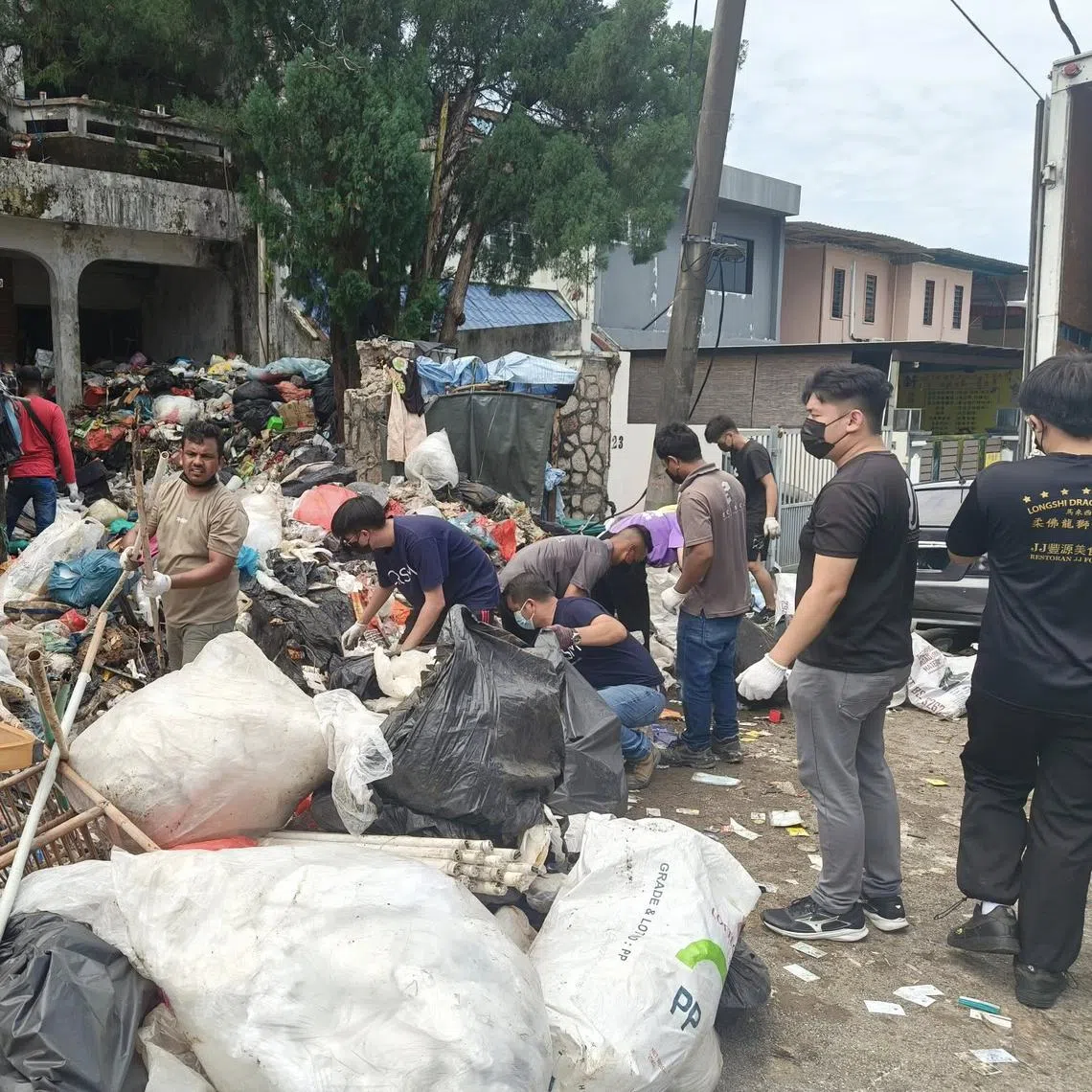 Volunteers removing the massive volume of waste at the man's double-storey house in Taman Sentosa, Johor.